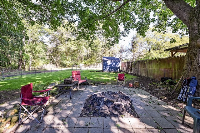 view of patio / terrace featuring a storage shed and an outdoor fire pit