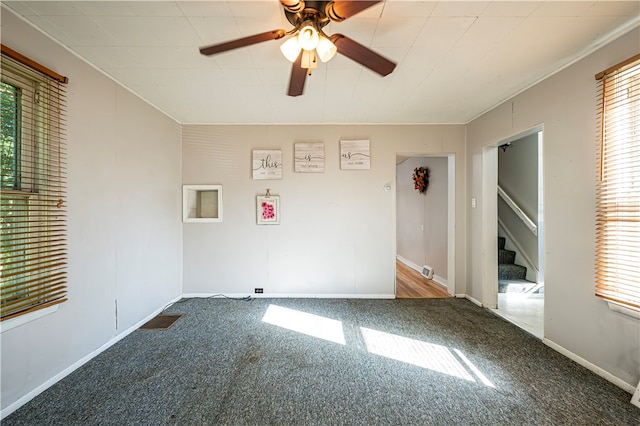 empty room featuring ceiling fan, crown molding, and carpet flooring