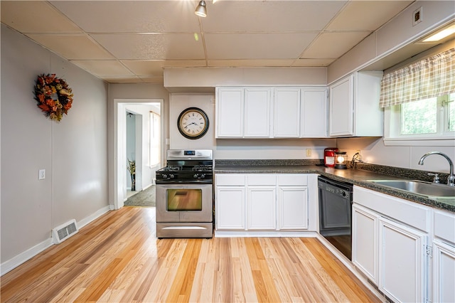 kitchen featuring white cabinets, black dishwasher, light wood-type flooring, and stainless steel range with gas stovetop