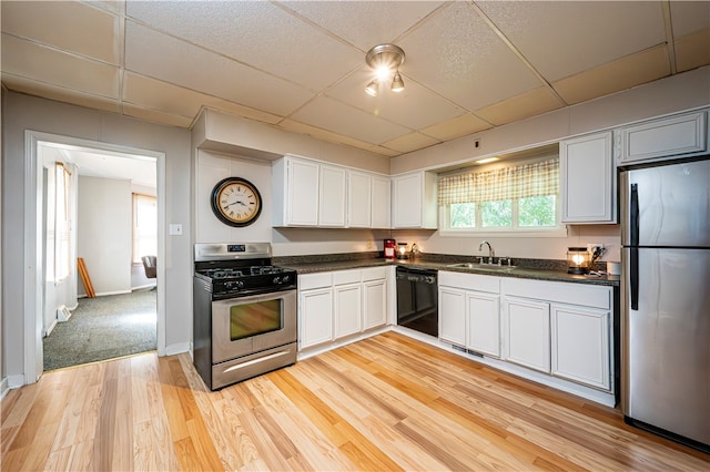 kitchen with light wood-type flooring, sink, white cabinetry, a paneled ceiling, and stainless steel appliances