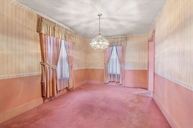 carpeted empty room featuring a notable chandelier