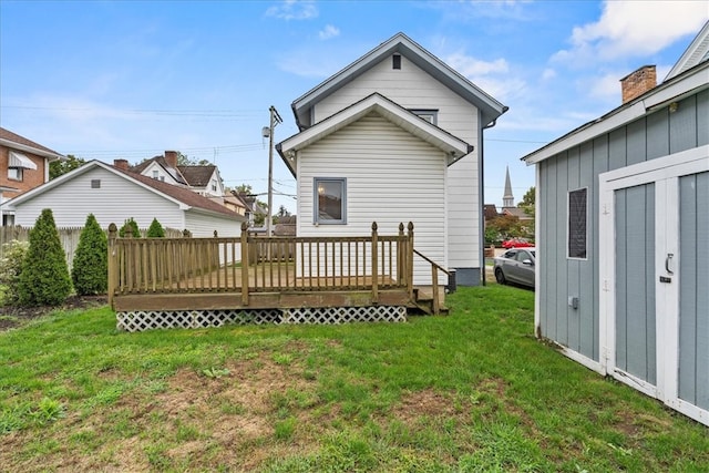 back of house with a deck and a lawn