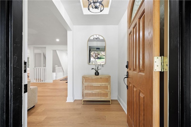 entryway featuring light wood-type flooring and a notable chandelier