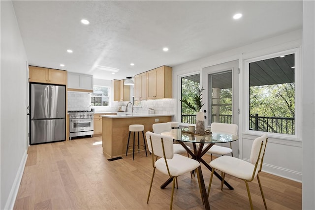 dining area with light wood-type flooring and sink