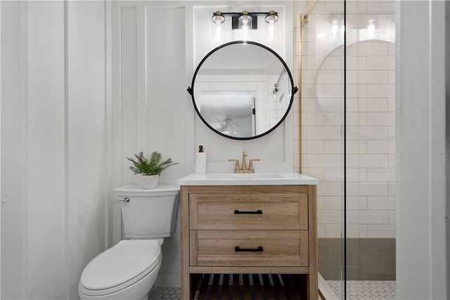 bathroom featuring vanity, toilet, and a tile shower