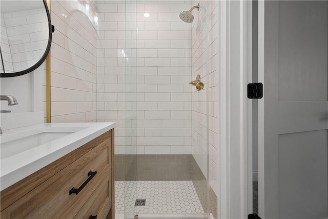 bathroom with a tile shower and vanity