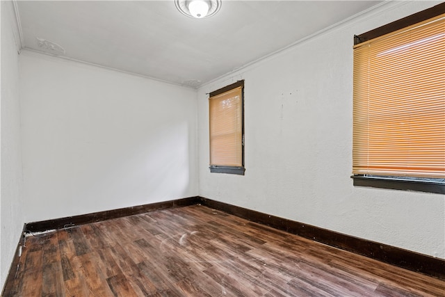 empty room with hardwood / wood-style flooring and ornamental molding