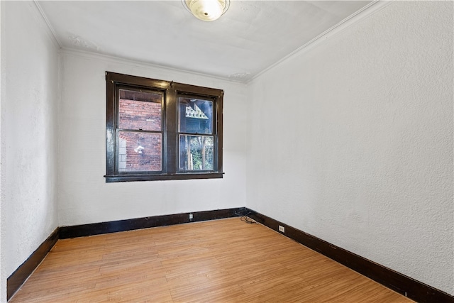 empty room with wood-type flooring and crown molding