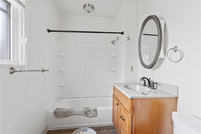 full bathroom with hardwood / wood-style flooring, bathing tub / shower combination, vanity, and toilet