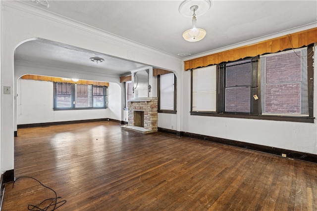 unfurnished living room with hardwood / wood-style flooring, a fireplace, and crown molding