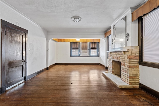 unfurnished living room featuring a textured ceiling, ornamental molding, and dark wood-type flooring