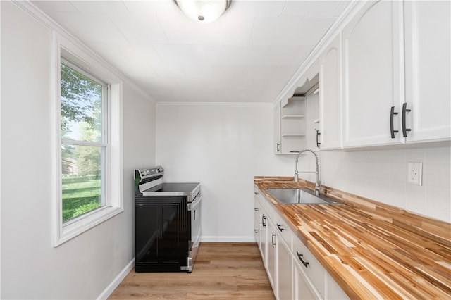 kitchen featuring electric range oven, butcher block counters, plenty of natural light, and sink