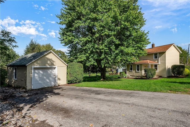 view of front of house featuring an outbuilding, a garage, and a front lawn