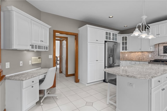 kitchen with decorative light fixtures, white cabinetry, light stone counters, and high end fridge