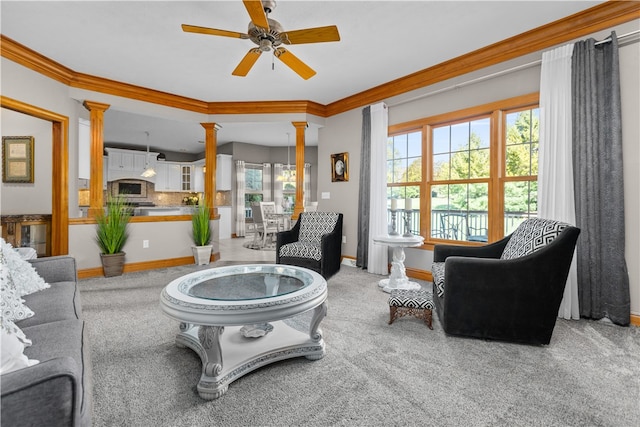 carpeted living room featuring ornamental molding, decorative columns, and ceiling fan