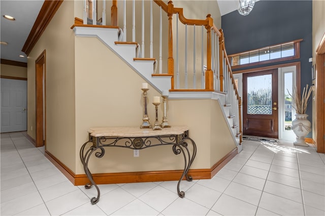 foyer entrance with ornamental molding and light tile patterned floors