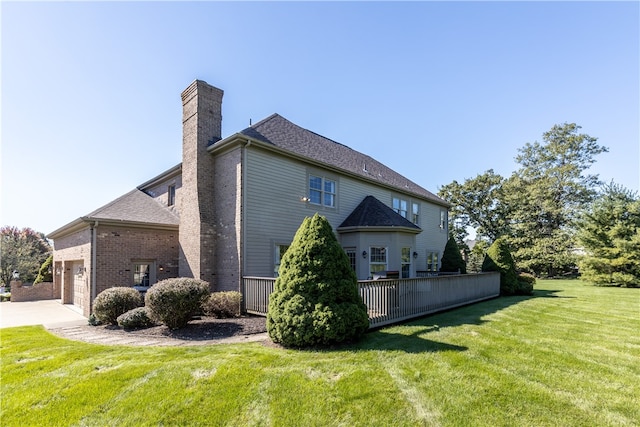 back of property featuring a garage and a yard