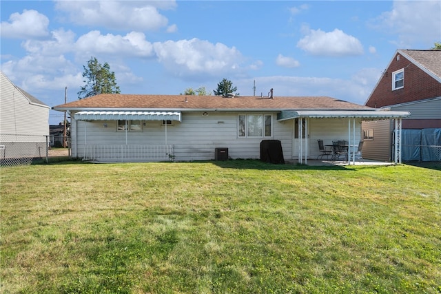 back of house with a lawn and a patio