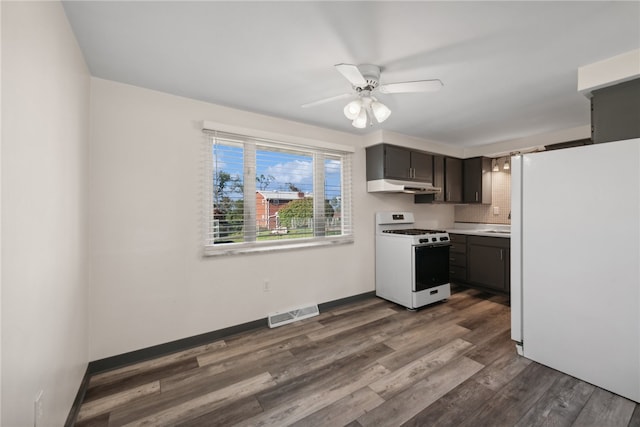 kitchen featuring white appliances, dark hardwood / wood-style floors, ceiling fan, and tasteful backsplash