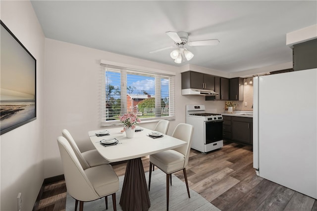 kitchen with white appliances, ceiling fan, tasteful backsplash, and dark hardwood / wood-style flooring