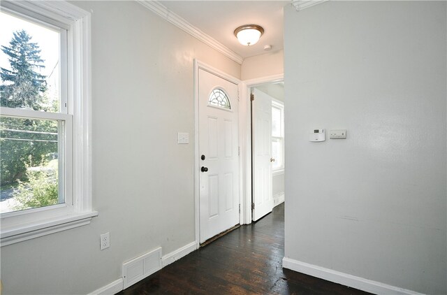 foyer entrance with ornamental molding and dark wood-type flooring