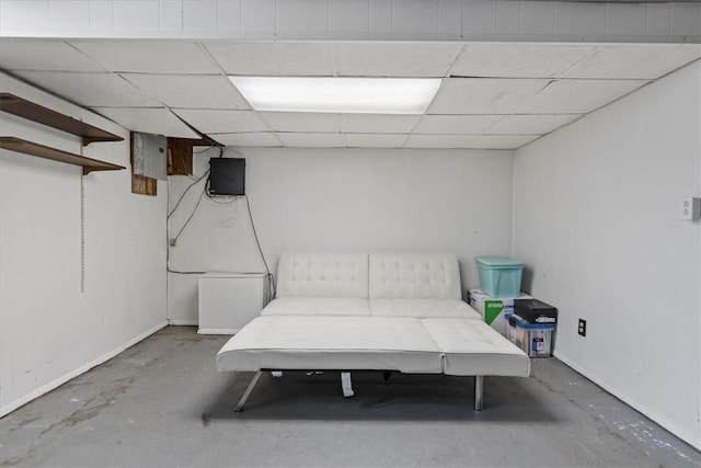 unfurnished bedroom featuring a drop ceiling, electric panel, and concrete flooring