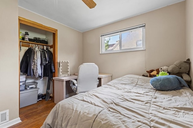 bedroom with dark hardwood / wood-style floors, ceiling fan, and a closet