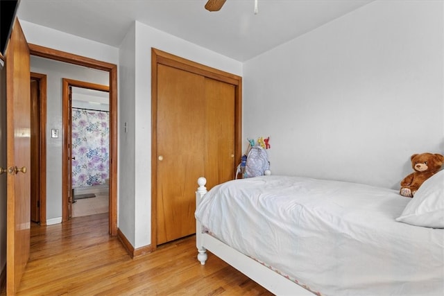 bedroom with ceiling fan, light hardwood / wood-style flooring, and a closet