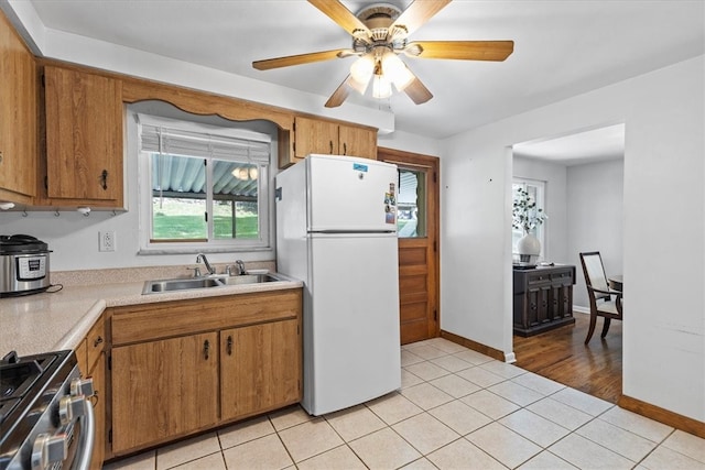 kitchen with ceiling fan, sink, stainless steel range, light wood-type flooring, and white fridge