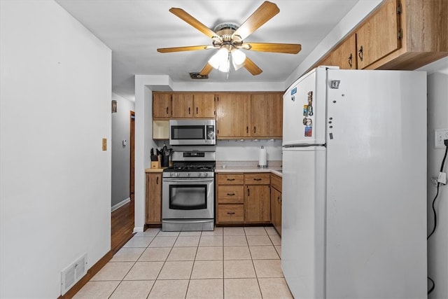 kitchen featuring stainless steel appliances, ceiling fan, and light tile patterned floors