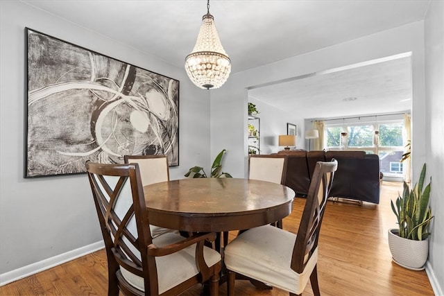 dining space featuring a notable chandelier and wood-type flooring