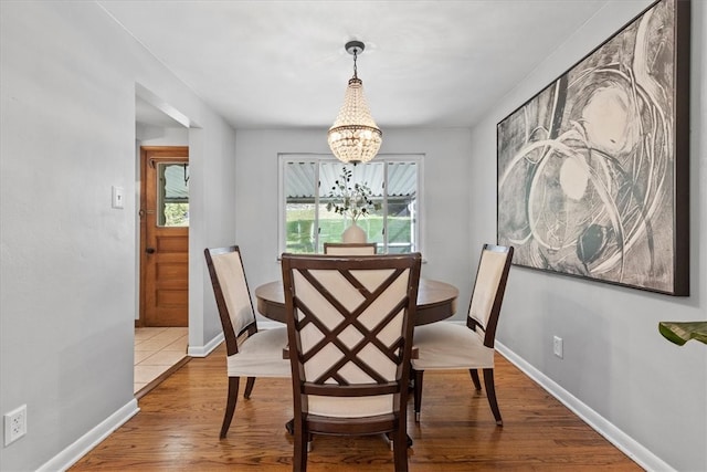 dining space featuring an inviting chandelier and hardwood / wood-style flooring