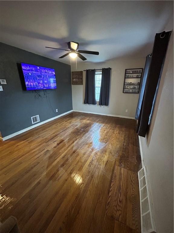 unfurnished living room featuring hardwood / wood-style floors and ceiling fan