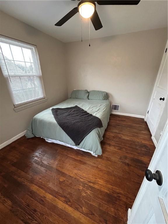 bedroom with dark hardwood / wood-style floors and ceiling fan