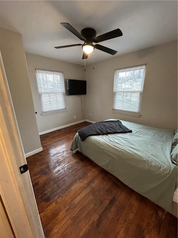 bedroom featuring ceiling fan and dark wood-type flooring