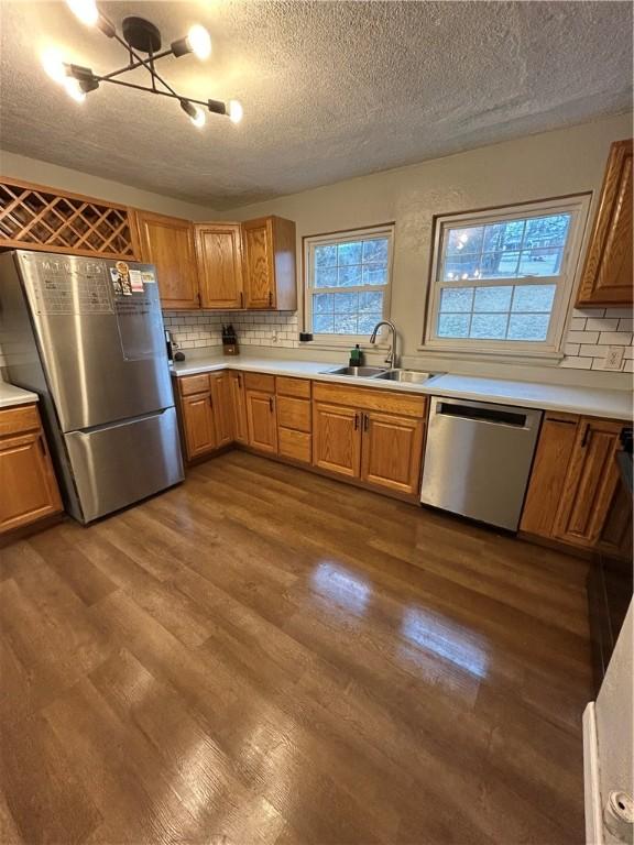 kitchen featuring dark hardwood / wood-style flooring, sink, stainless steel appliances, and tasteful backsplash