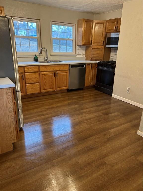 kitchen featuring plenty of natural light, dark hardwood / wood-style flooring, sink, and appliances with stainless steel finishes