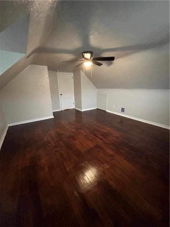 bonus room featuring a textured ceiling, ceiling fan, dark hardwood / wood-style flooring, and lofted ceiling