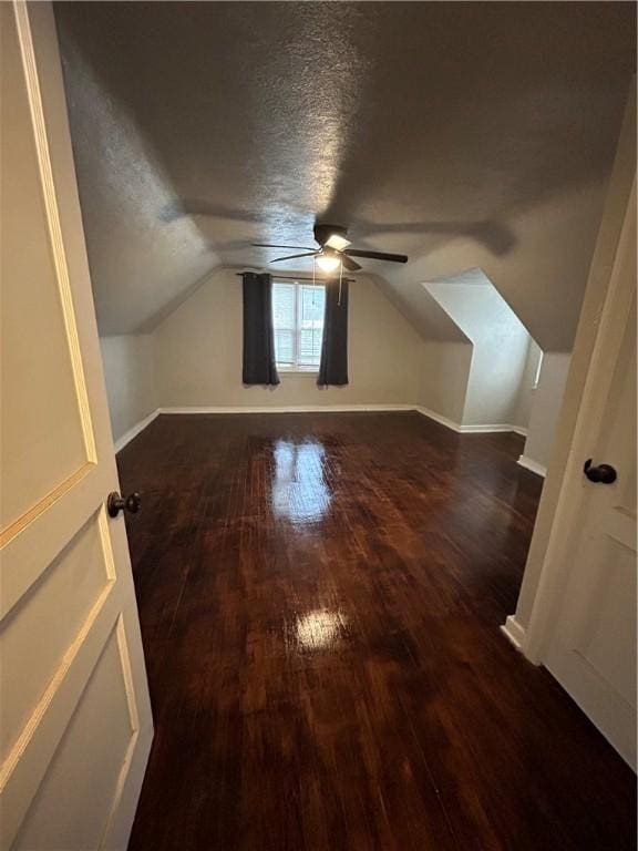 additional living space with dark hardwood / wood-style floors, ceiling fan, lofted ceiling, and a textured ceiling