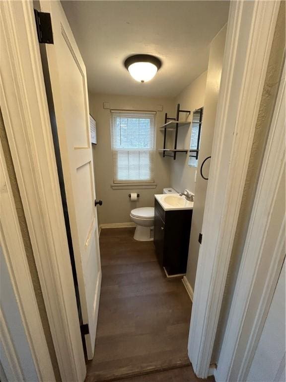 bathroom with hardwood / wood-style floors, vanity, and toilet