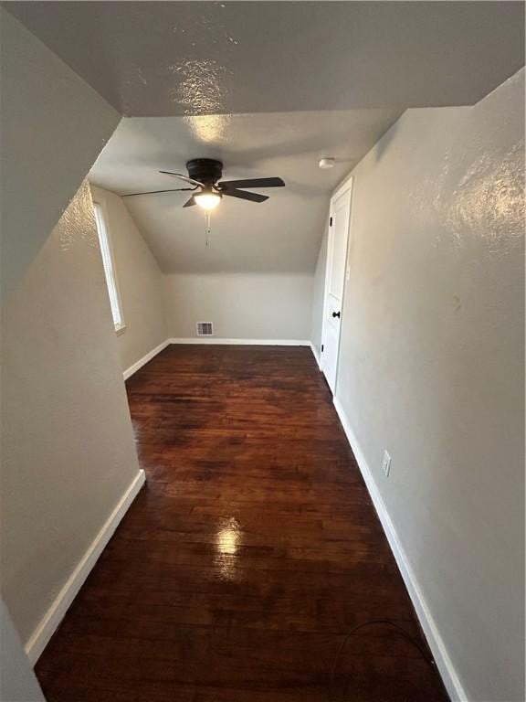 additional living space with ceiling fan, dark hardwood / wood-style floors, and vaulted ceiling