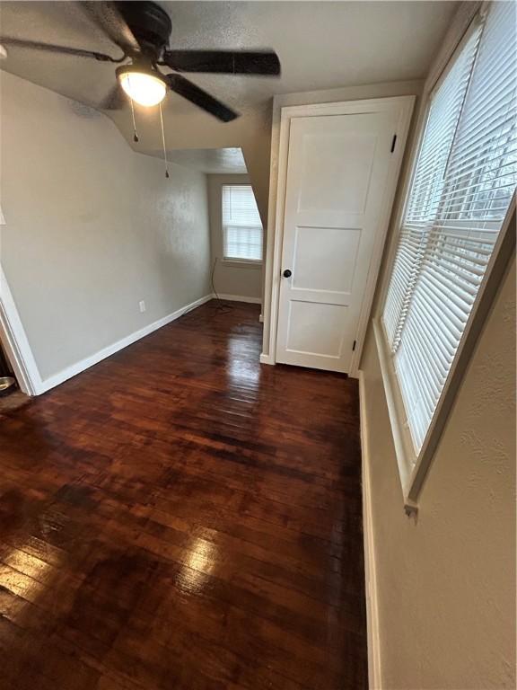 empty room with dark hardwood / wood-style flooring and ceiling fan