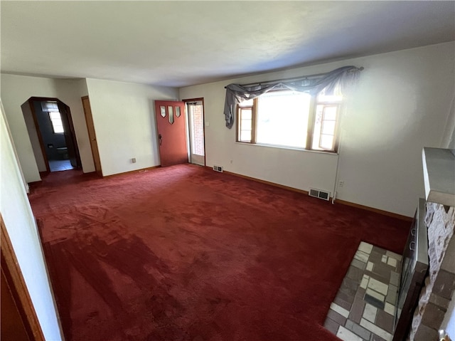 unfurnished living room with dark carpet