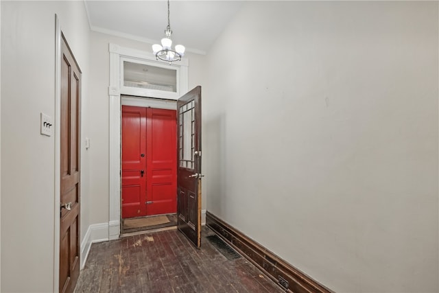 entryway featuring a chandelier, dark wood-type flooring, and crown molding