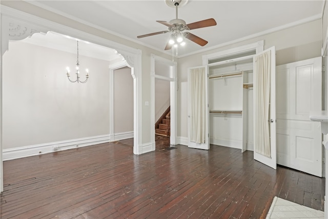 unfurnished living room with ceiling fan with notable chandelier, dark wood-type flooring, and crown molding