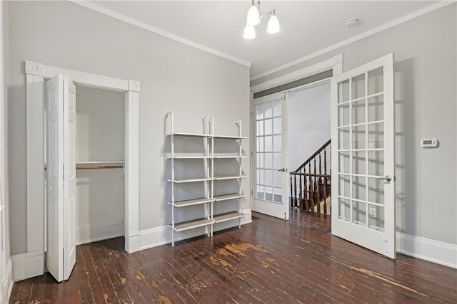 interior space featuring an inviting chandelier, a closet, dark hardwood / wood-style floors, and crown molding