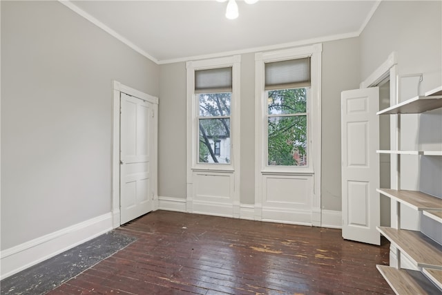 empty room with crown molding and dark wood-type flooring