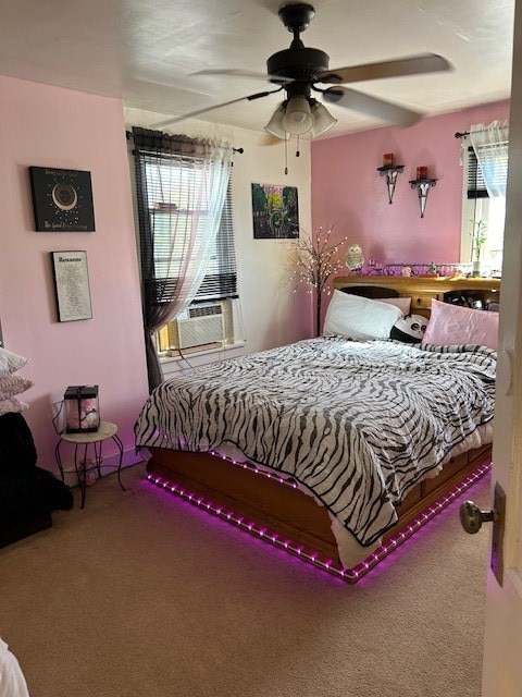 carpeted bedroom with ceiling fan, cooling unit, and multiple windows