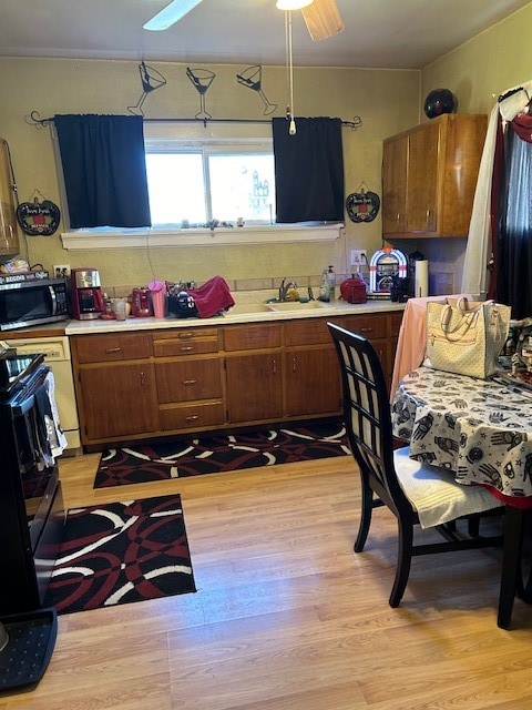 kitchen with ceiling fan, sink, and light hardwood / wood-style floors