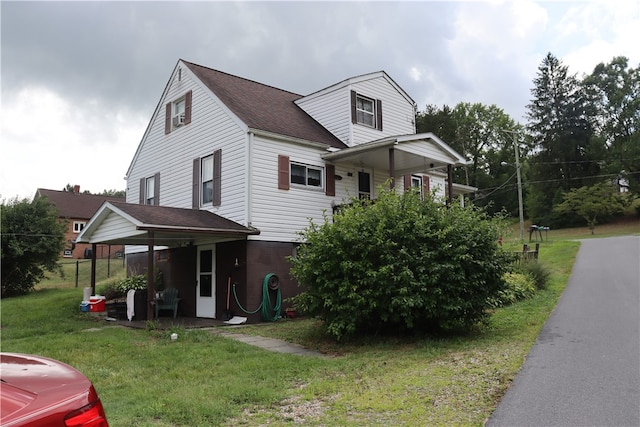 view of front of house featuring a front lawn and a carport